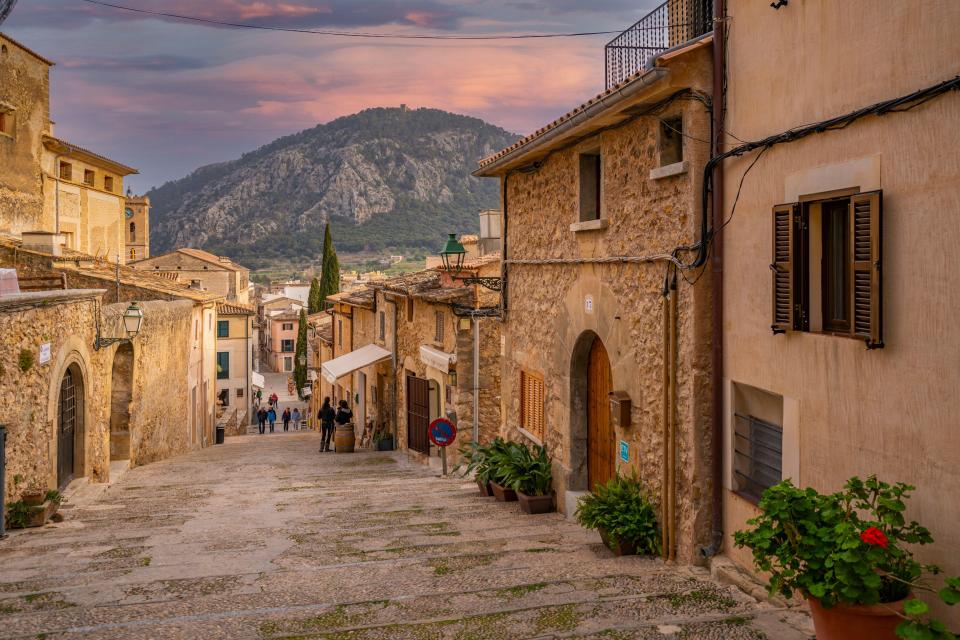 Stone stairway in Pollenca, Majorca, leading uphill towards a mountain.