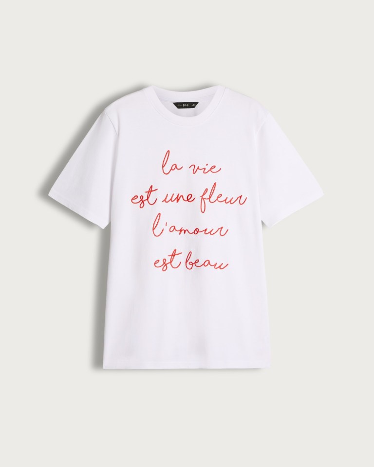 White t-shirt with red French phrase: "la vie est une fleur l'amour est beau".