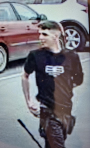 Low-quality surveillance image of a person wearing a black shirt.