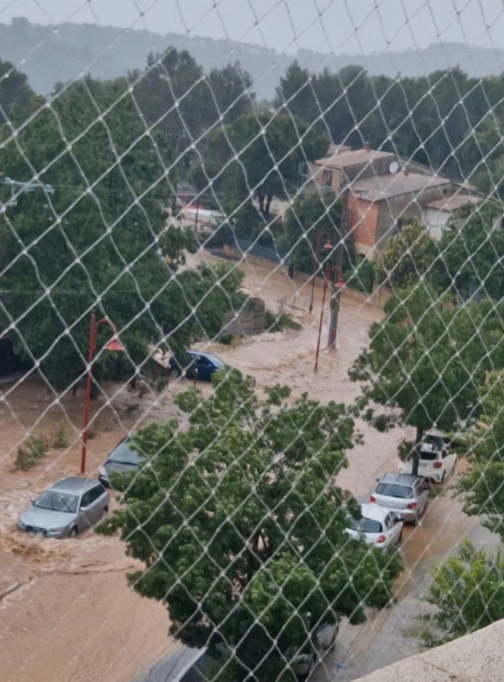 Cars submerged in floodwaters on a street.