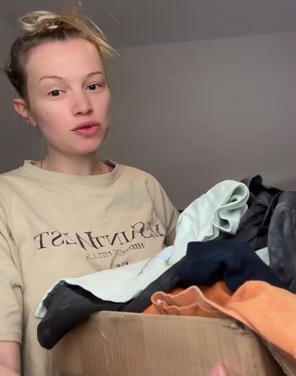 Woman packing clothes into a box.