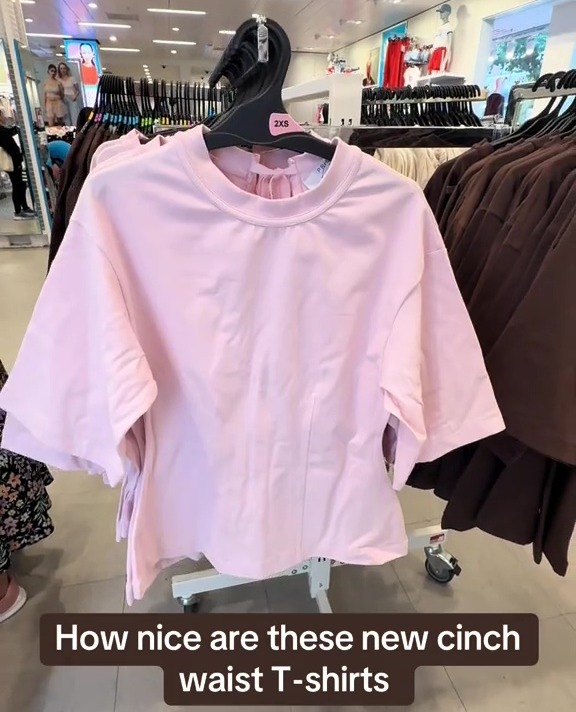 Pink cinch waist T-shirts on display in a store.
