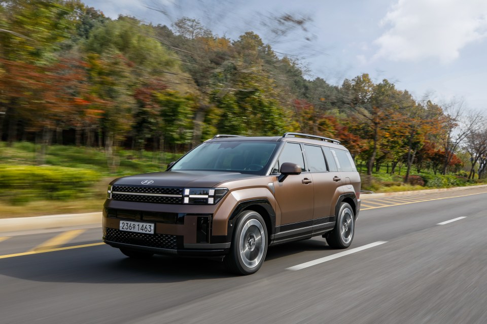 Brown SUV driving on a road.