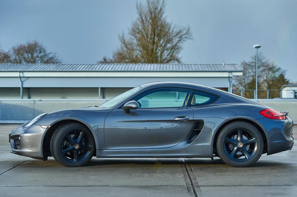 Gray Porsche Cayman parked in a parking lot.