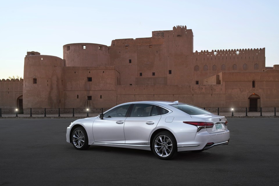 Lexus LS 500h parked in front of a castle.