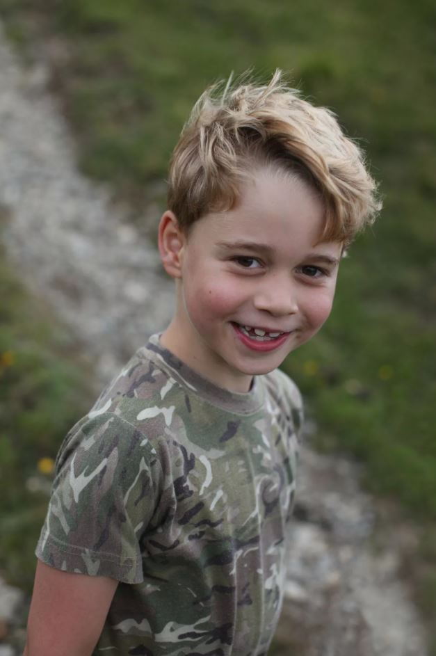 Portrait of a boy smiling, wearing camouflage.