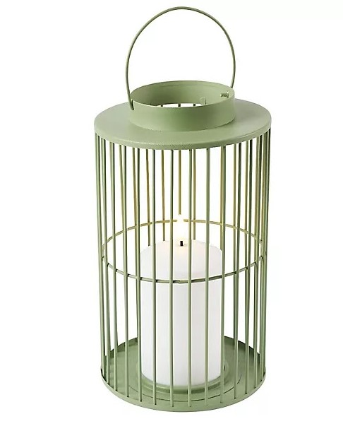 Sage green metal lantern with candle inside.