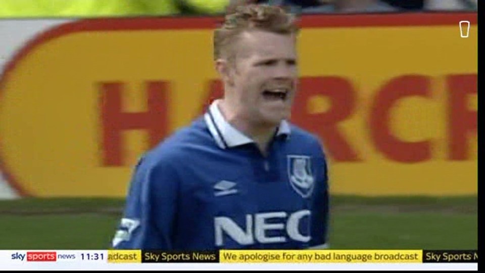 A soccer player in a blue jersey with "NEC" on the front, looking angry.