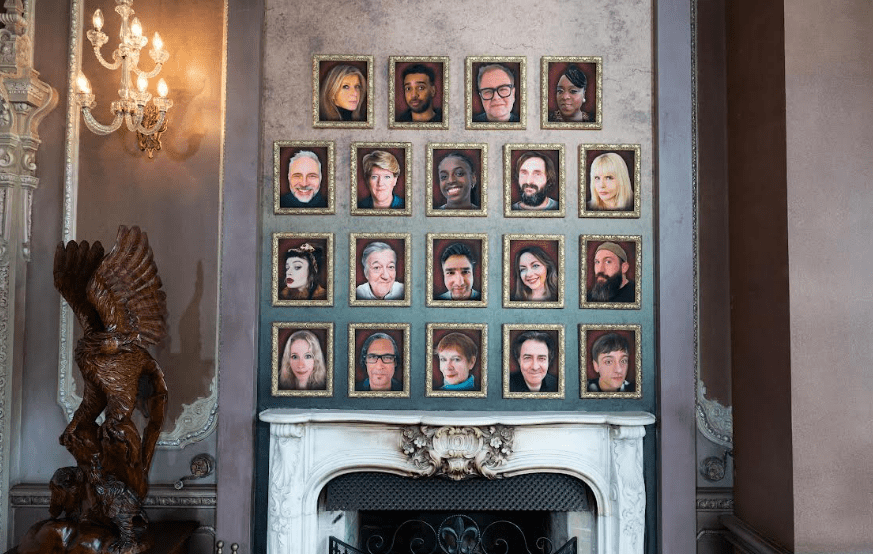 Wall of framed portraits of Celebrity Traitors 2025 contestants.