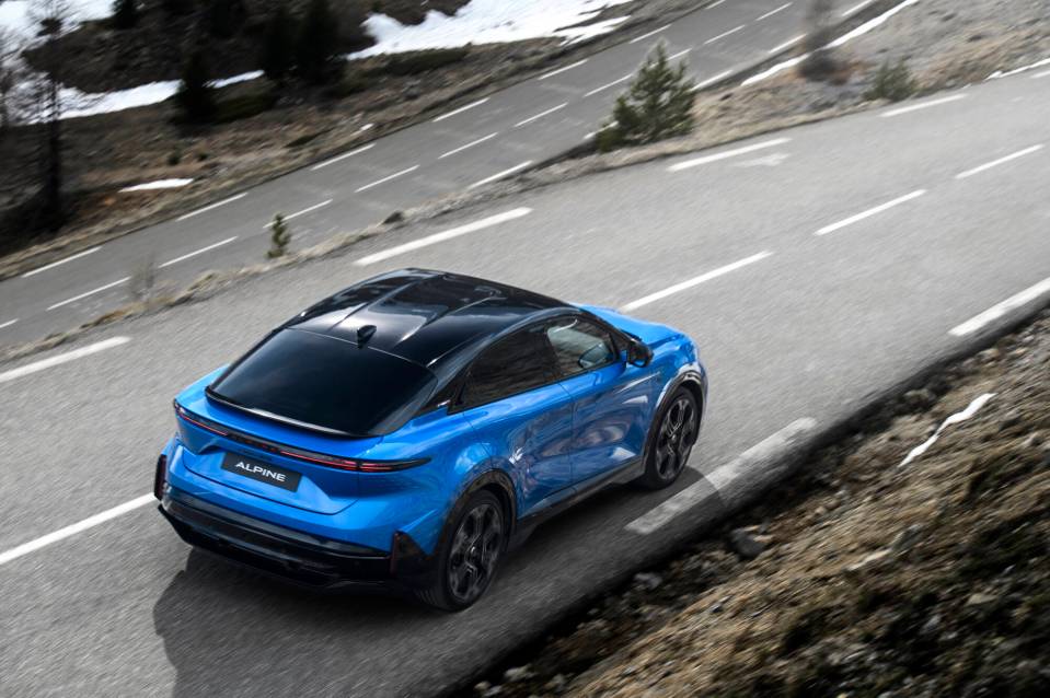 Blue Alpine A390 driving on a mountain road.