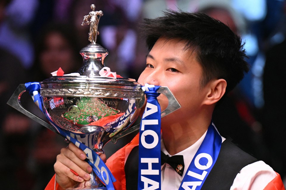 China's Zhao Xintong kisses the trophy after victory over Wales' Mark Williams in the World Championship Snooker final at The Crucible in Sheffield, northern England on May 5, 2025. Zhao Xintong became the first Chinese player to win the World Snooker Championship as the qualifier completed his stunning march to the title with a 18-12 victory against Mark Williams in the final on Monday. (Photo by Oli SCARFF / AFP) (Photo by OLI SCARFF/AFP via Getty Images)