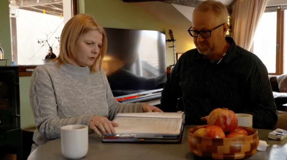 A man and woman review paperwork at a table.