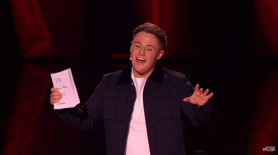 A man holding a stack of papers on stage.