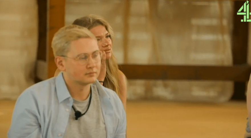 Screenshot of two people sitting indoors.