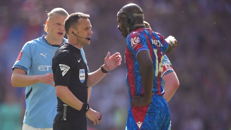 Referee speaking to a soccer player.