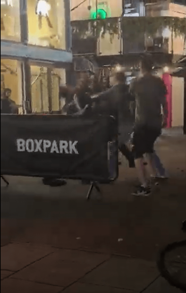 A bar brawl outside Boxpark; a bouncer is punched to the ground.