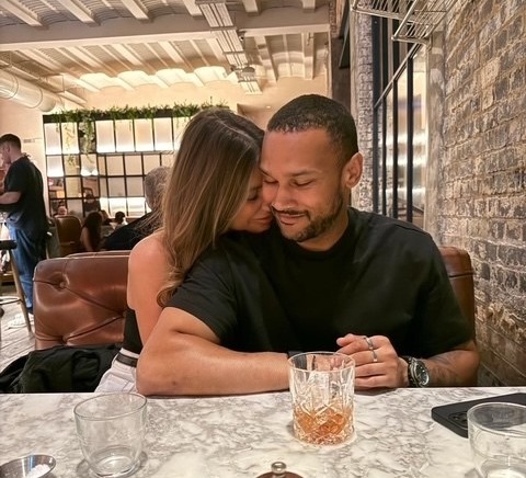 Couple embracing at a restaurant table.