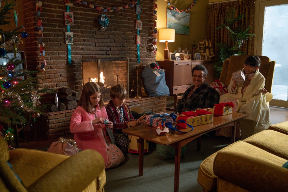 Scene from Call the Midwife Christmas special: a family opens presents by a fireplace.