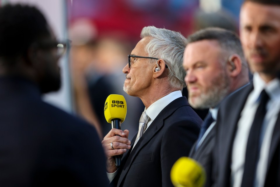 Man in suit and glasses speaking on television.