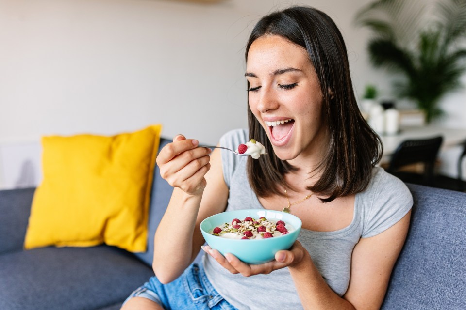 Woman enjoying a healthy breakfast of yogurt and fruit.