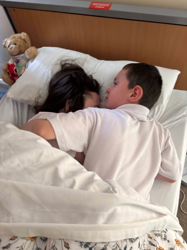 A boy and girl cuddling in bed.