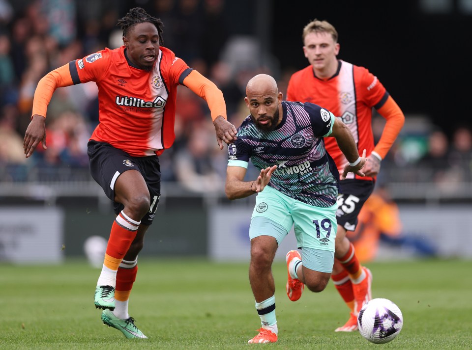 Bryan Mbeumo of Brentford challenged by Pelly Ruddock Mpanzu of Luton Town during a Premier League match.
