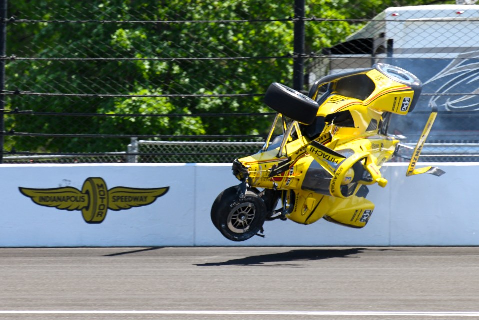 A yellow race car airborne after hitting a wall at the Indianapolis Motor Speedway.