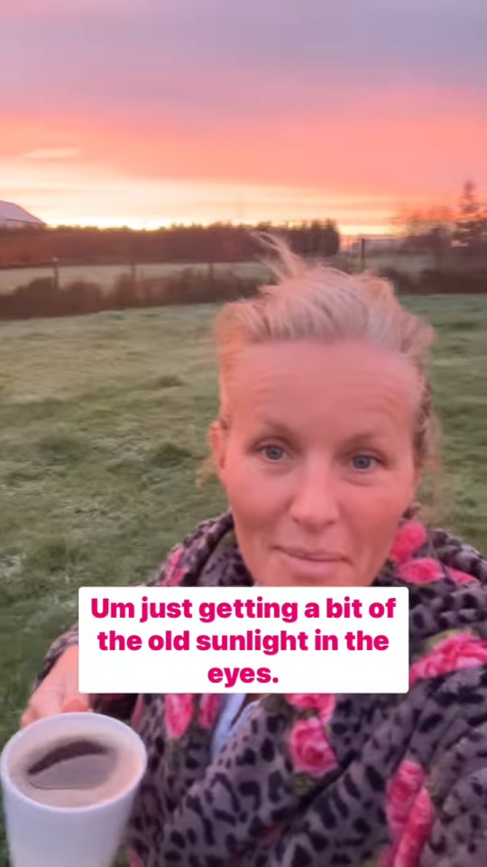 Woman holding a coffee cup at sunrise.
