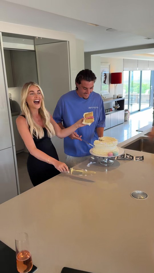 Claudia Fogarty and her partner cutting a gender reveal cake.