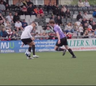 Two soccer players vying for the ball during a match.