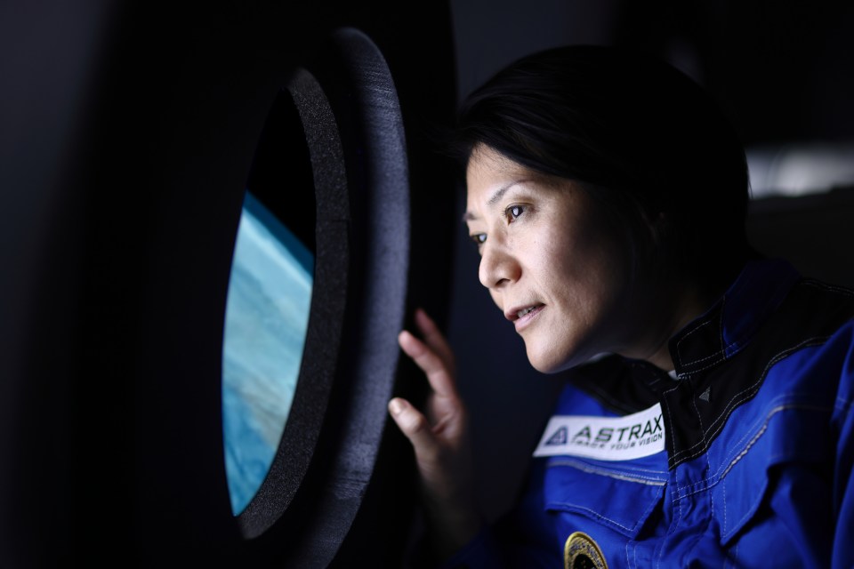 A space tourist gazing at Earth from a spaceship window.