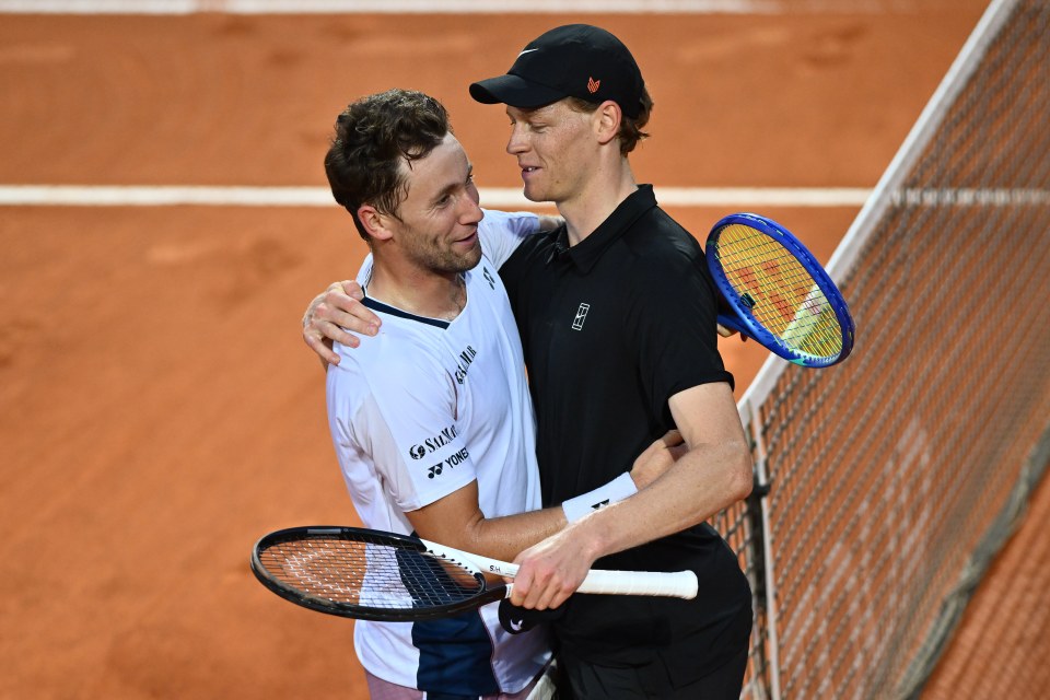 Jannik Sinner and Casper Ruud embracing after a tennis match.