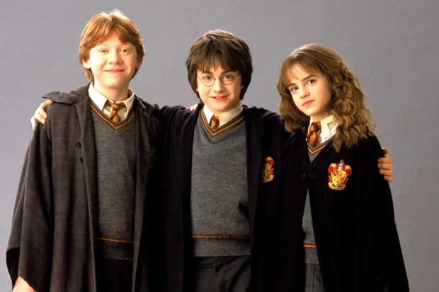 Harry Potter, Ron Weasley, and Hermione Granger in their Hogwarts robes.