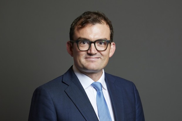 Portrait of a man in a suit and glasses.