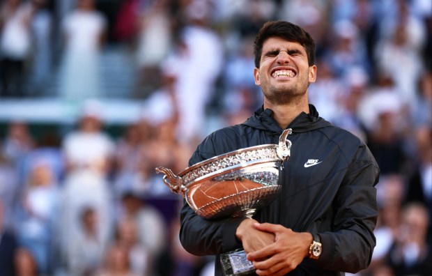 Carlos Alcaraz holding a trophy.