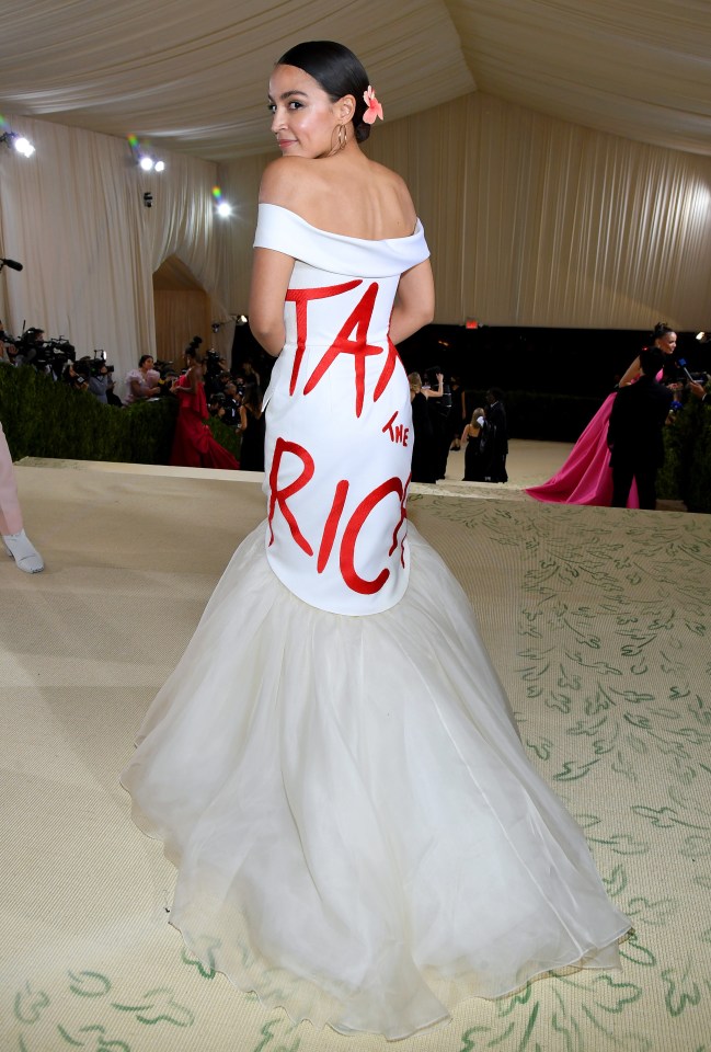 Alexandria Ocasio-Cortez at the Met Gala in a white gown with "Tax the Rich" written on the back.