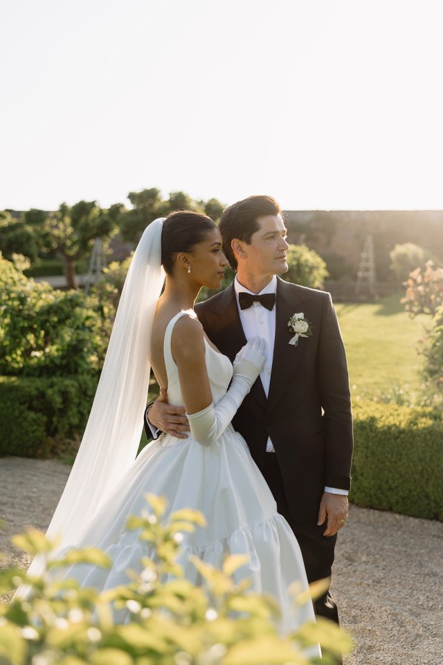 Bride and groom embracing outdoors.