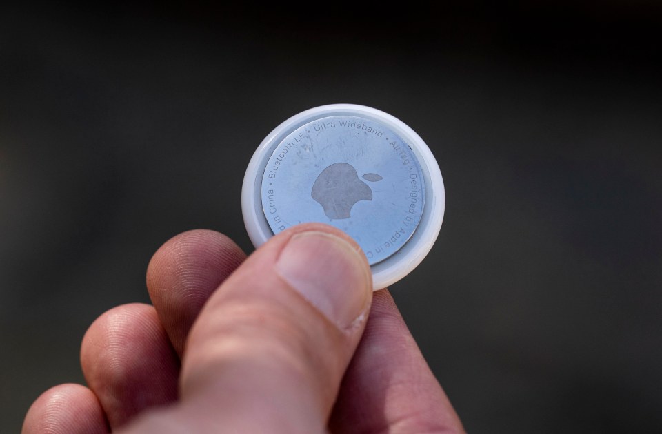 Close-up of a person holding an Apple AirTag.