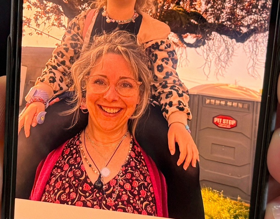 A person displays a phone photo of a woman and child.