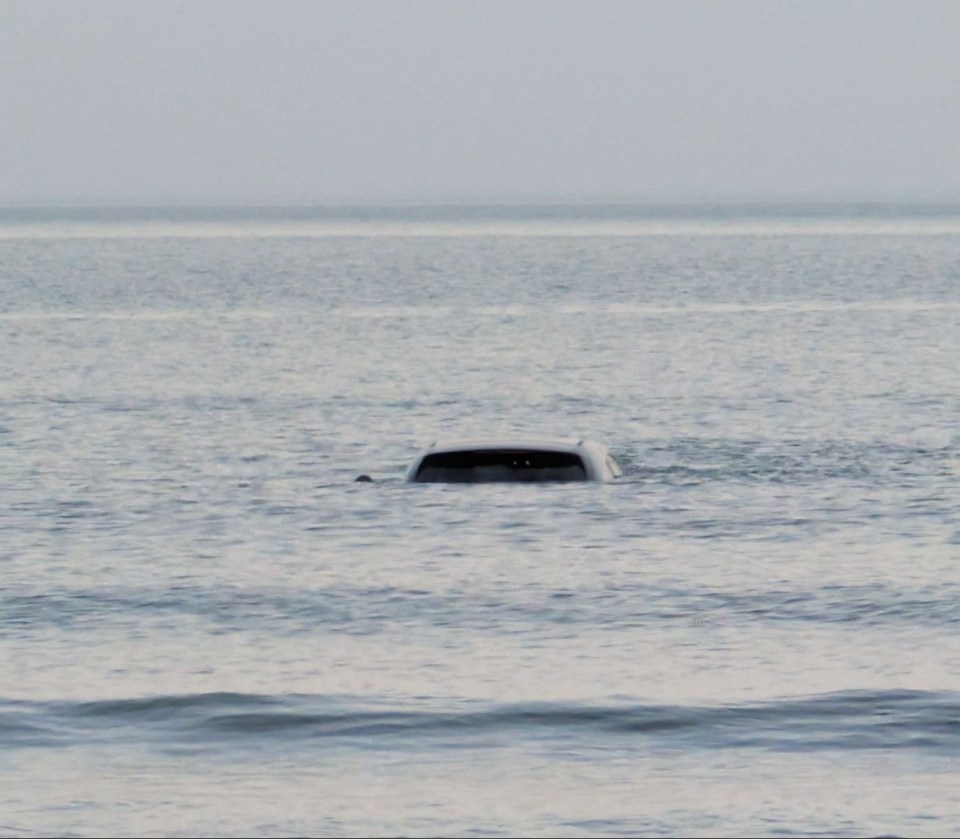 Car submerged in ocean water.
