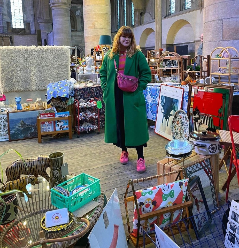 Woman in green coat at a car boot sale.