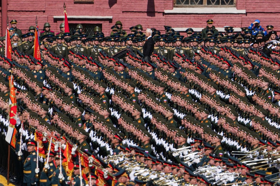 Military officer saluting during a parade.