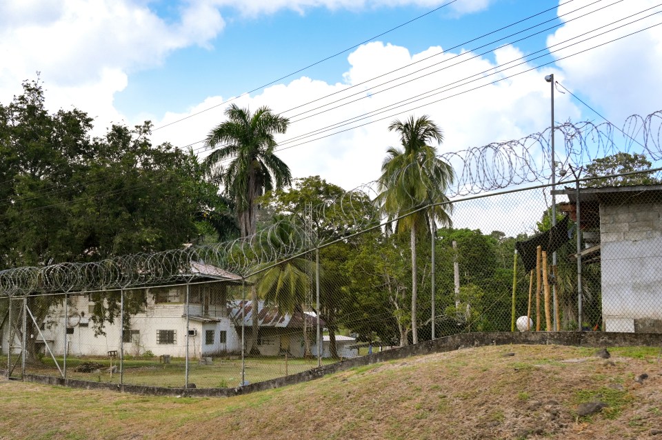 Prison exterior with razor wire fence.