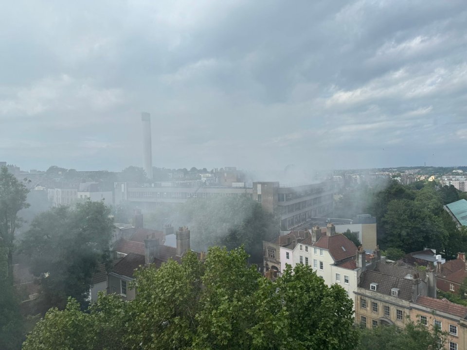 Smoke billowing from a building fire in Bristol, viewed from afar.