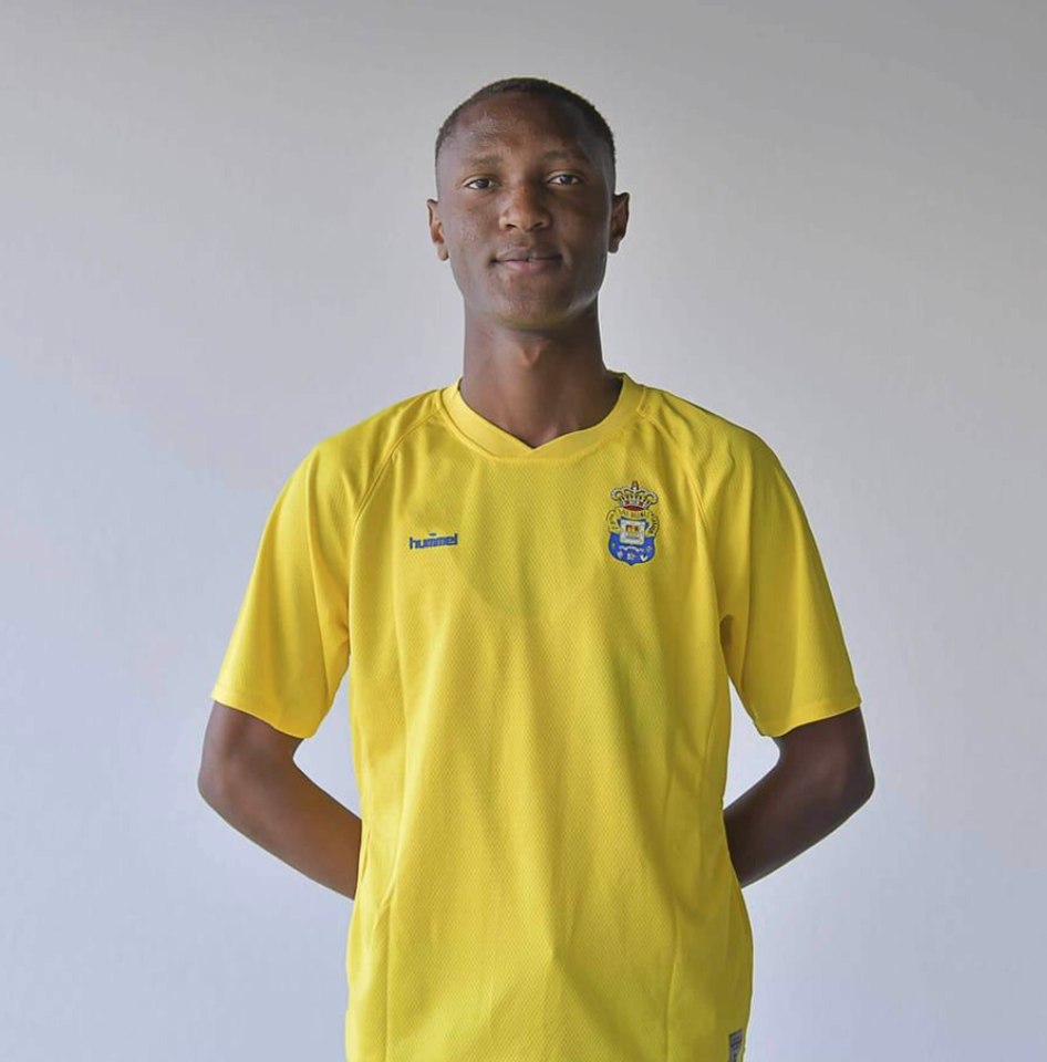 Portrait of a young man in a yellow soccer jersey.