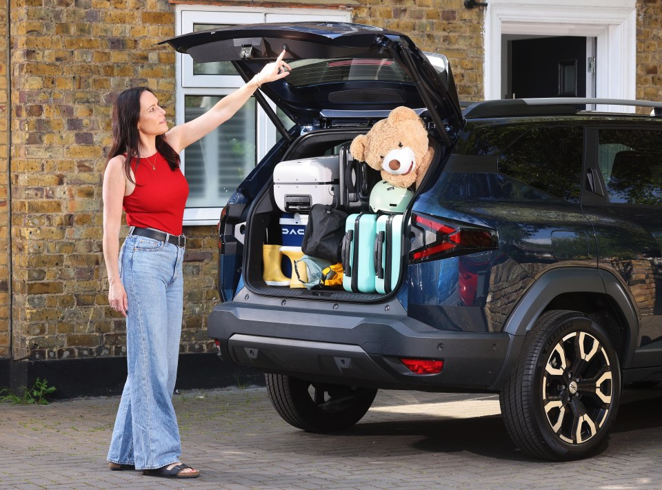 Woman packing a car's trunk with luggage.