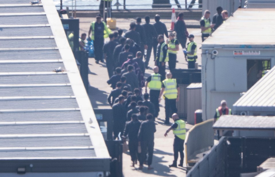 Migrants led through a Border Force compound.