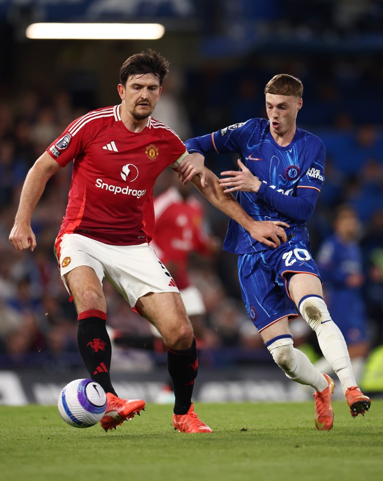 Harry Maguire of Manchester United is challenged by a Chelsea player during a soccer match.