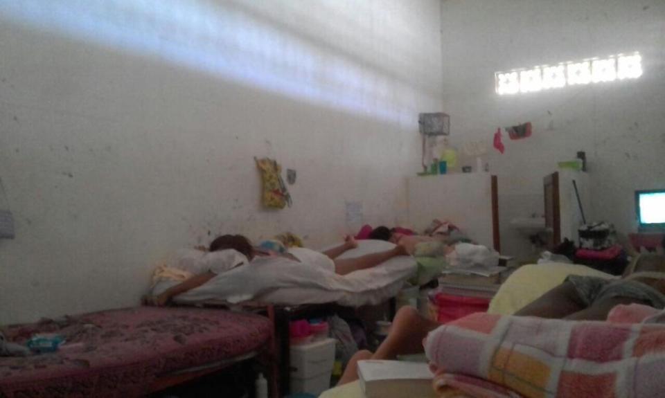 Photo of a South American prison cell with several inmates sleeping on bunk beds.