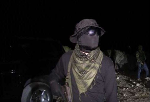 Person wearing tactical gear at night.
